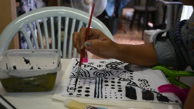 Thai woman people painting natural color indigo on fabric at workshop in Nonthaburi, Thailand