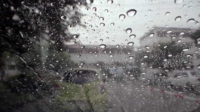 Rain drops on the glass on a rainy day with slow motion.