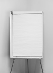 Bulk white flipchart over a white corner wall, ideal for mockup and presentation