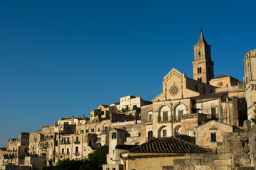 Fototapeta na wymiar Horizontal View of the City of Matera at Sunset on Clear Blue Sky Background