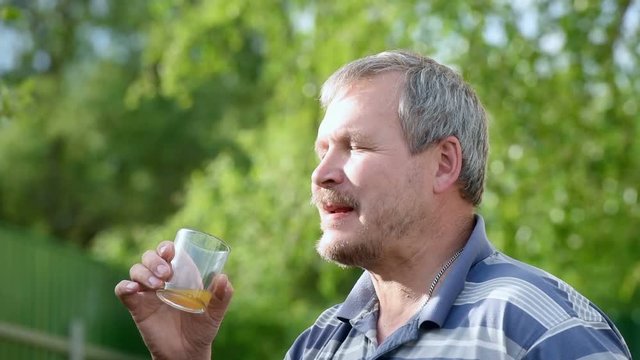 Man happy to drink juice in nature in the summer