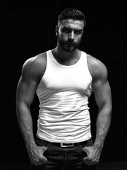 Monochrome portrait of a strong man with a beard. He looks at the camera with different emotions. 