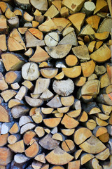 Pile of chopped stacked firewood, prepared for heating house in winter  as abstract textured background.