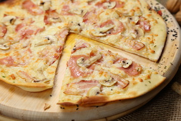 Pizza thin with sausage, mushrooms, cheese, spices, a glass of juice, tomatoes, nuts