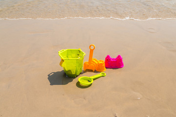 Fototapeta na wymiar Children's beach toys - buckets, spade and shovel on sand on a sunny day