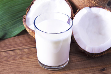 coconuts and glass of coconut milk with wooden background