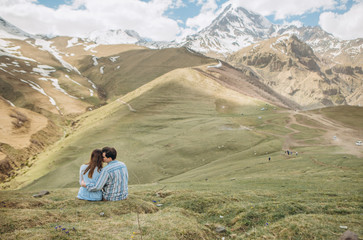 Fototapeta na wymiar guy girl hugging grass summer big mountains snow