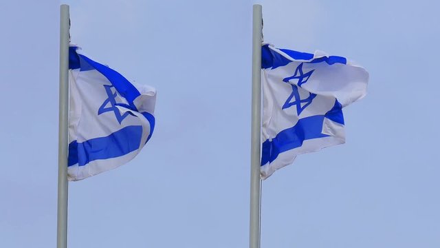 Closeup of two flags of Israel waving at strong wind