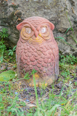 Close-up of a terracotta owl resting in the garden.