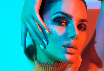 Foto op Plexiglas Mannequin vrouw in kleurrijke felle lichten met trendy make-up en manicure poseren in studio © Subbotina Anna