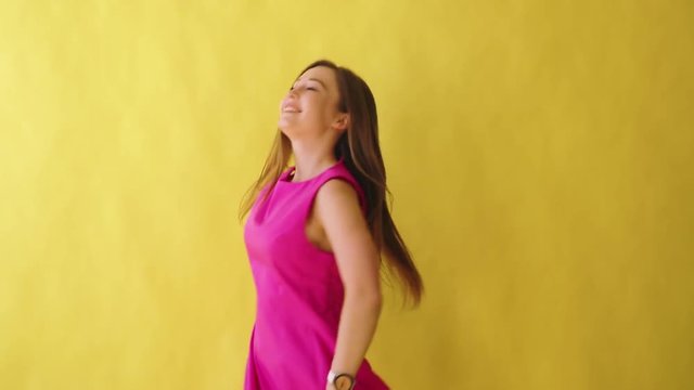 young attractive adult girl in elegant pink dress on yellow background