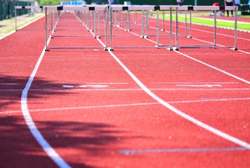 A hurdle race on red running in stadium track; success concept.