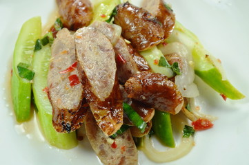 spicy slice Chinese pork sausage with cucumber Thai salad on white plate