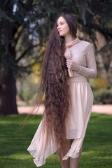 Portrait einer Frau mit knielangen braunen Haaren im rosa Kleid