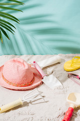 Sandy beach with towel, hat and summer accessories with copy space. Vacation and travel items. Tropical Holiday Background.