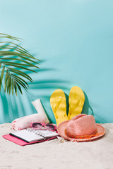 Sandy beach with towel, hat and summer accessories with copy space. Vacation and travel items. Tropical Holiday Background.