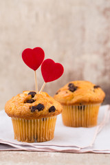 Homemade chocolate muffins with heart, vintage background.