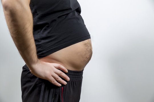 Adult man is showing his fat, unhealty belly