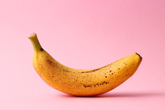 a ripe and sweet banana with dots on a colored background. minimalism.