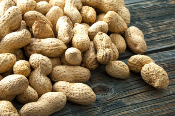 Raw peanuts on old wooden boards.