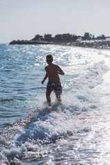 Boy running in water on the beach