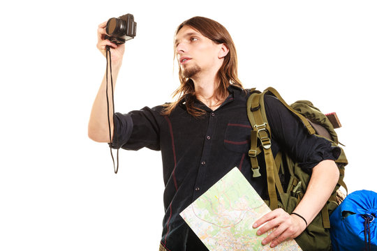 Man tourist backpacker taking photo with camera.