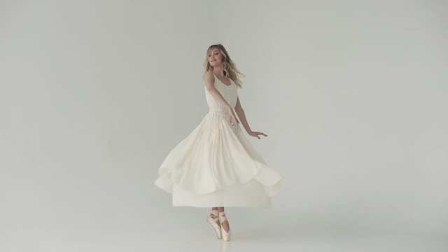 lightness, beauty and grace of a young girl dancing ballet. A ballerina in beige pointe shoes and a light long dress. cloth fluttering during the dance
