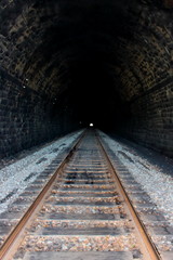 Fototapeta na wymiar Longest dark railway tunnel soft focus. The length of the tunnel is 778 meters located on the Polovinnaya (Half) Station of the Circum-Baikal Railway. View of the light at the end of the tunnel