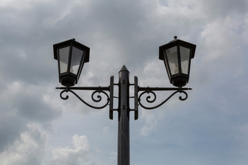 Vintage iron lantern on a city street on a cloudy day
