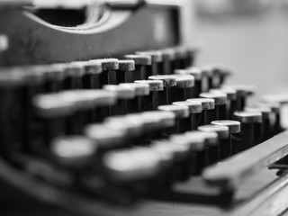 Dusty antique typewriter with focus on the keys in black and white