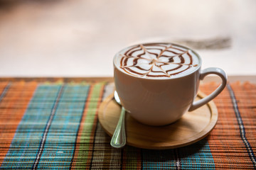 Cappuccino cup on bar table near window in the restaurant