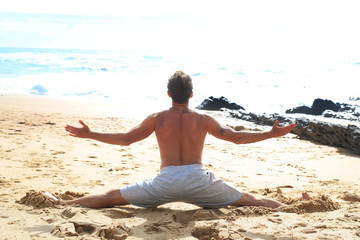 Fototapeta na wymiar Man doing an exercise on the beach against the ocean