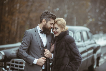 Close up of a beautiful young couple in love walking together at a retro car.