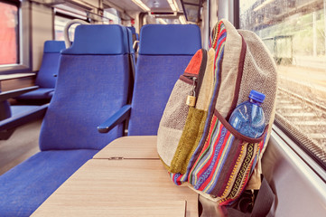 Backpack on the train near the window. Travel conceptual image.