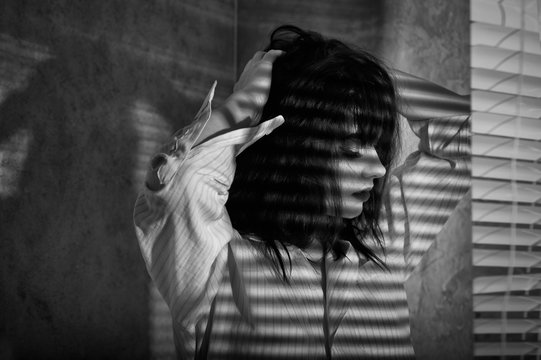 romantic girl in a shirt with shades of blinds on the body