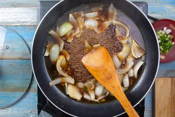 Chef stir fry onion in pan
