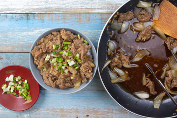 chef put slice of onion to cooked beef with rice