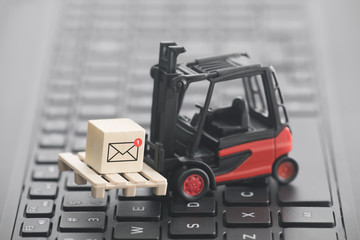 Forklift with new email graphic on wooden block over laptop keyboard 