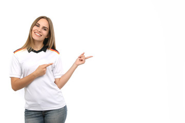 Hübsche blonde Frau in Deutschlandtrikot zeigt mit den Fingern in eine Richtung