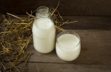 Bottle and glass of milk on table.