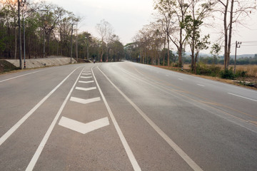 Obraz premium road up hill to the mountain top at at sunny sunset.