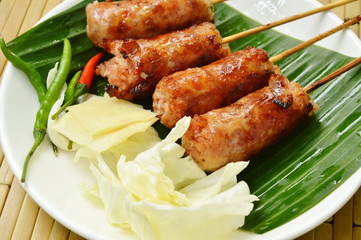 grilled Thai sausage stuffed rice and pork eat with fresh vegetable on plate