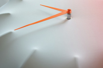 Closeup of light fabric wall clock face with orange arrows with copy space for text.