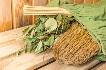 Three different brooms wrapped in a green towel in a bath