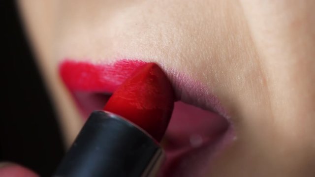 Female Applying Red Lipstick Top Lip. a slow motion close up view of female lips applying red lipstick to the upper lip