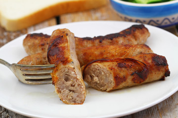 Crispy, fried British sausage on fork, closeup
