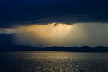 Beautiful rain storm in the Lake,with dark blue sky and lighting penetrate of the Sun