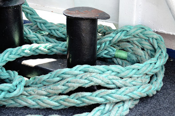Fototapeta na wymiar A strong rope aboard the ship. The rope is blue. Tackles for yachts
