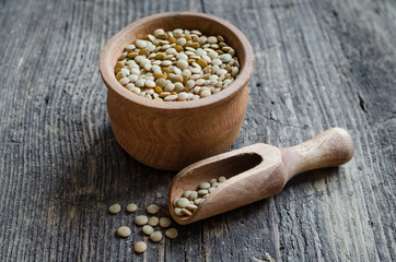 Brown dried lentils in a wooden bowl