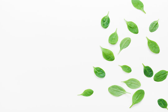 Organic and fresh spinach leaves on white background top view. Flat lay.